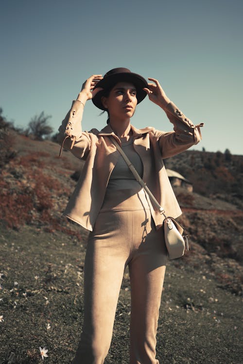 Woman in Sepia Pants and Blazer and Brown Hat