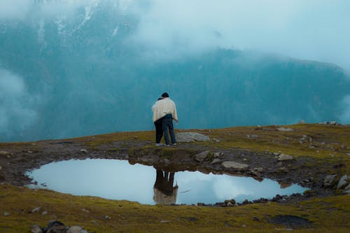 Couple Standing by a Small Alpine Pond during a Foggy Weather