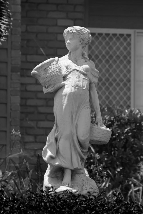 Free Black and white photo of an elegant garden statue holding baskets, capturing classic beauty. Stock Photo