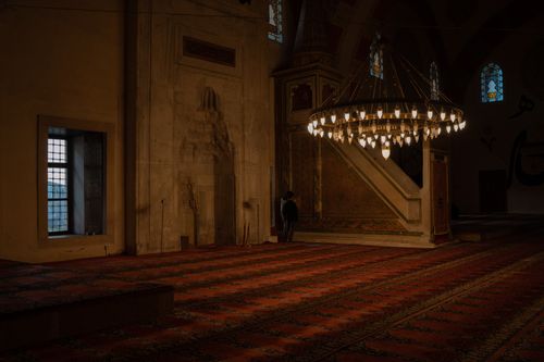 Free A serene interior of a mosque showcasing a beautifully illuminated chandelier and ornate decor, evoking a sense of peace and spirituality. Stock Photo