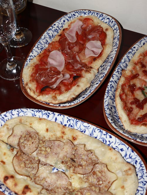 Closeup of Homemade Pizzas on Patterned Plates