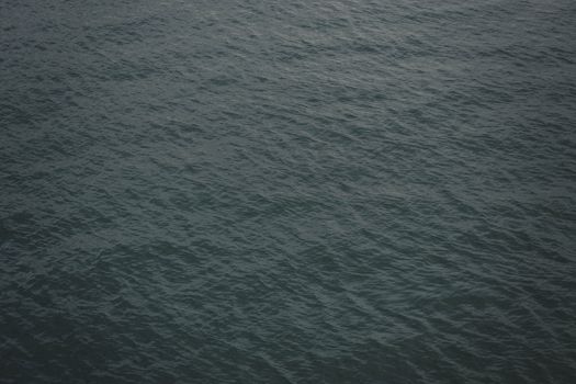 A serene view of the ocean with gentle waves creating a soothing texture on the water surface.