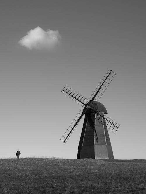 An Old Windmill and a Man on a Field 