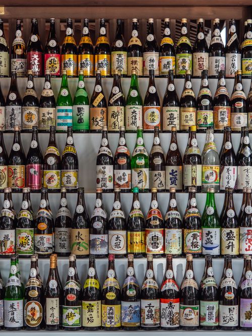 Free Vertical shot of sake bottles displayed on shelves in Shibuya City, Tokyo, Japan. Stock Photo
