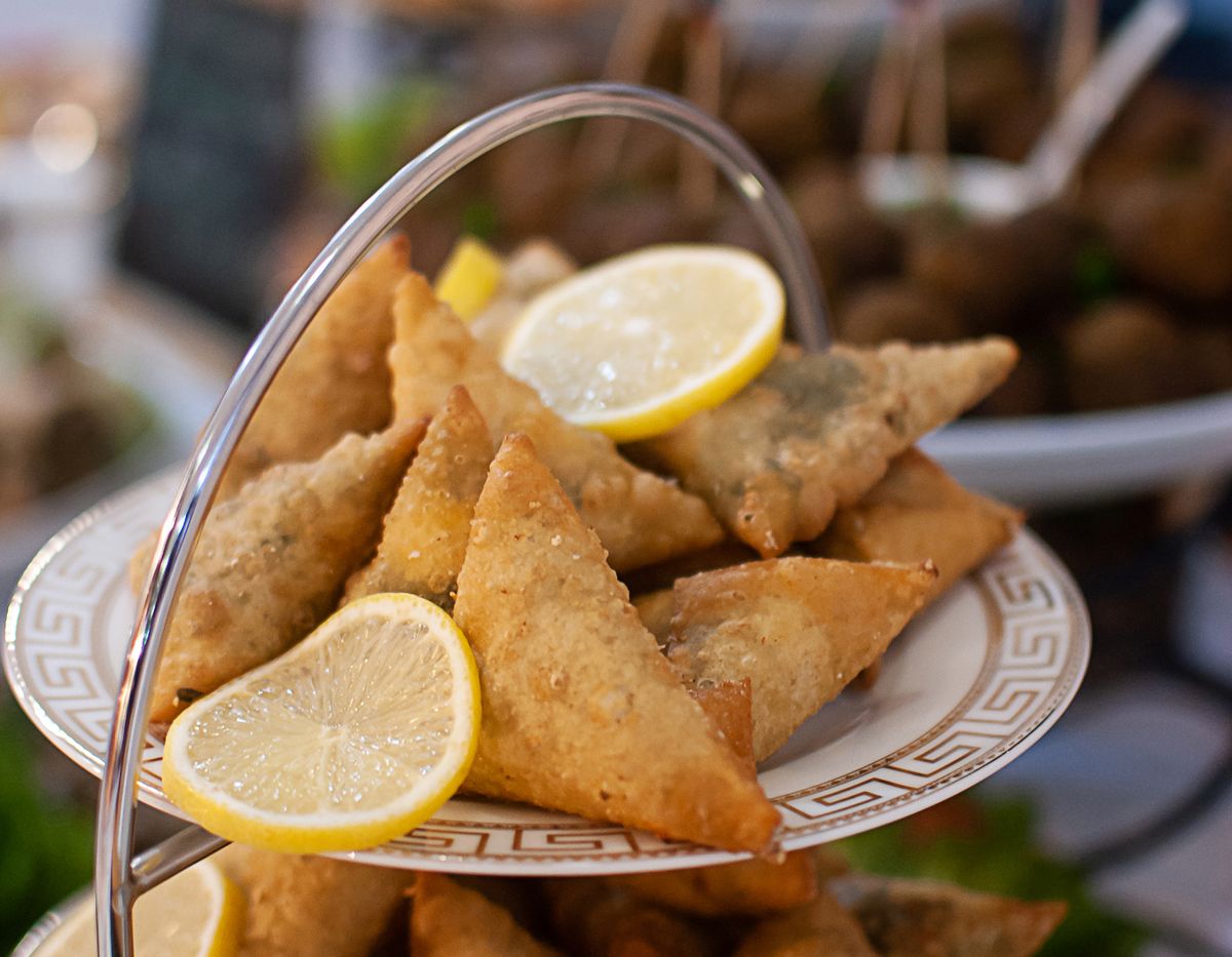 Samosas with lemon slices on a tiered serving tray