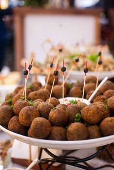 A plate of meatball appetizers with skewers and garnished with parsley, perfect for parties.