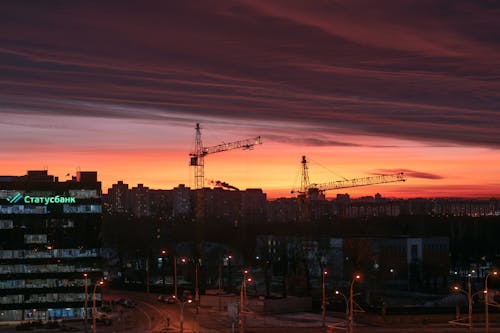 Cranes in City Skyline at Dusk