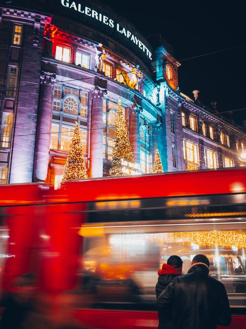 Free Blurred motion of a tram in front of illuminated Galeries Lafayette in Strasbourg at night. Stock Photo