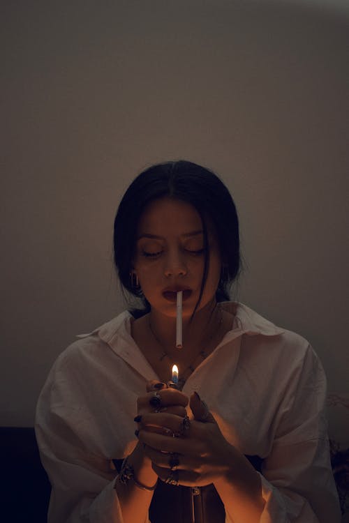 Portrait of a Pretty Brunette Lighting a Cigarette
