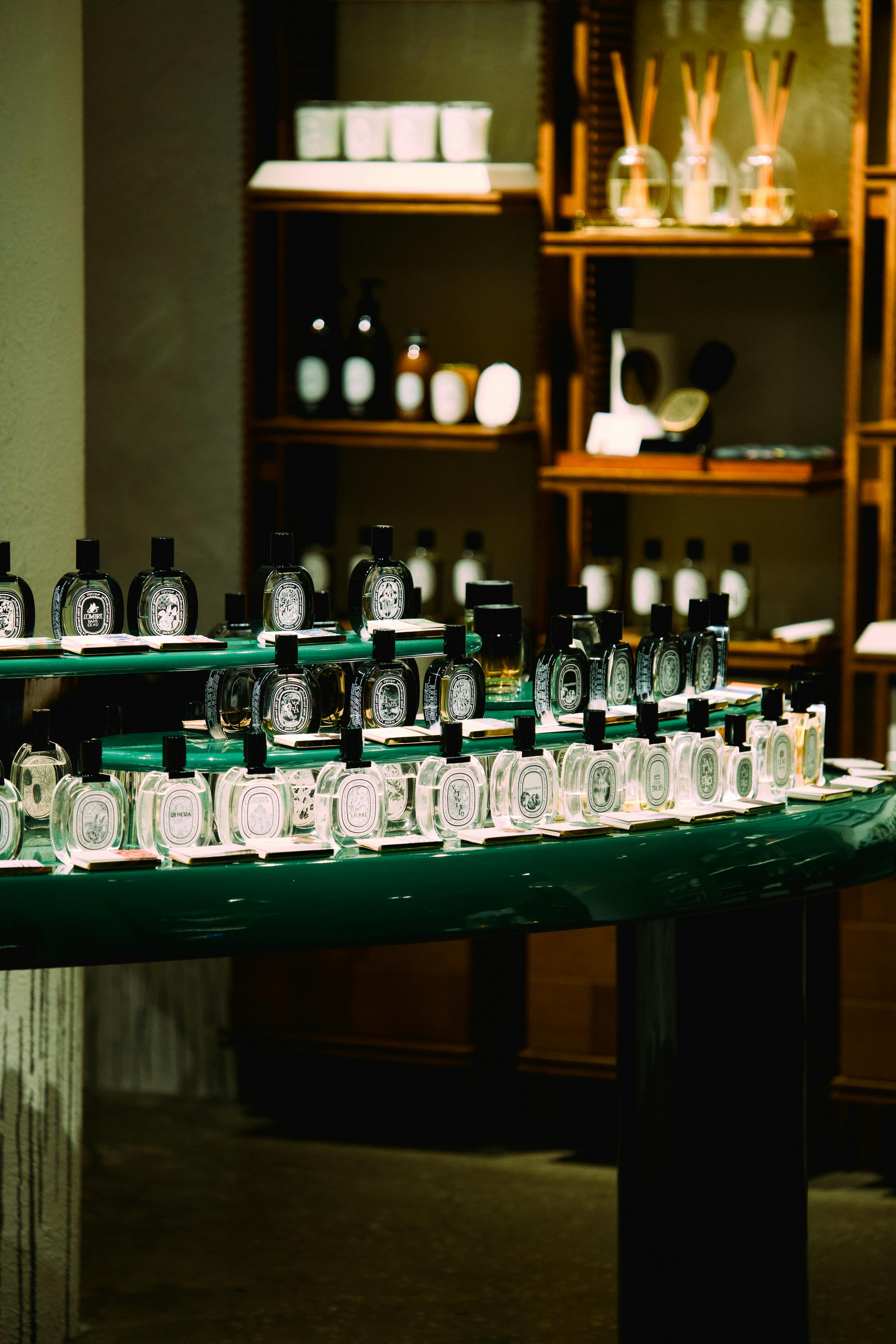 Perfume bottles grouped on a boutique shelf, echoing the carefully separated brand worlds luxury beauty groups try to preserve.