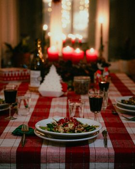 A warm and inviting holiday dinner setting with red candles and festive decor.