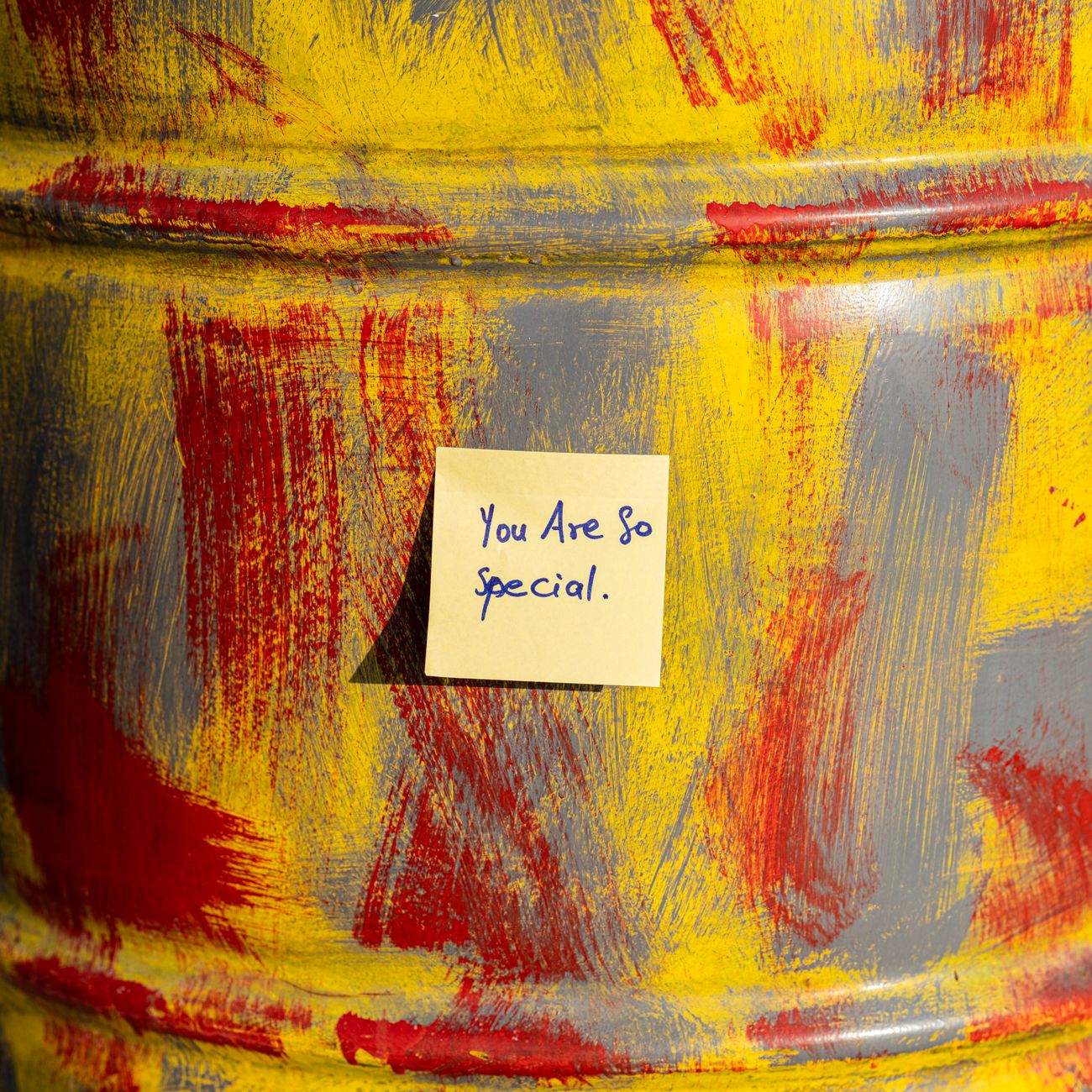 Close-up of a painted barrel with an inspirational sticky note reading 'You Are So Special.'
