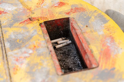 Cigarettes in a Colorful Thrash Bin 