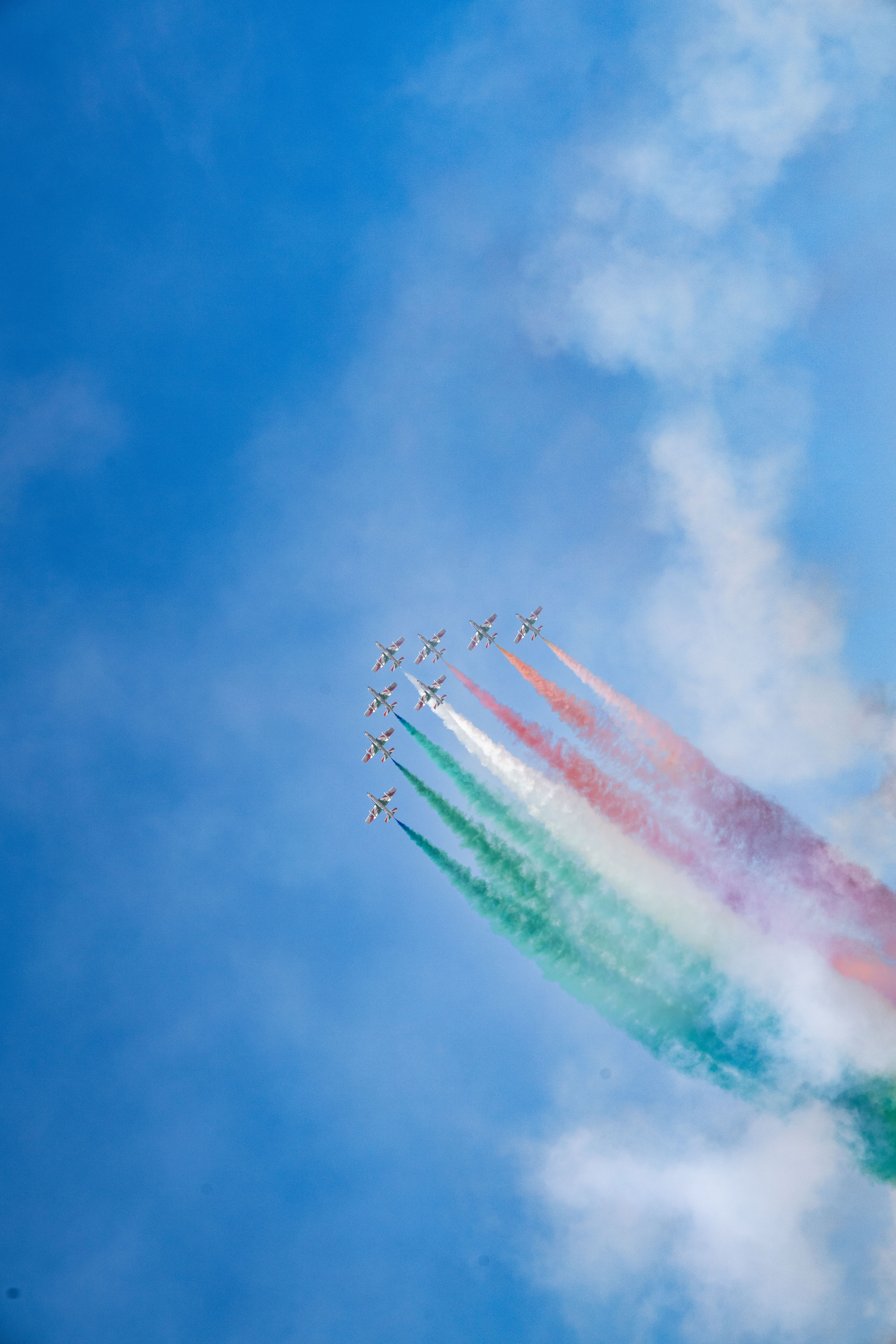 Aerobatic planes create a vibrant smoke trail in Dubai's sky.
