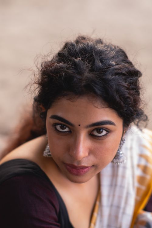 Free Close-up portrait of a South Asian woman wearing earrings, looking up. Stock Photo