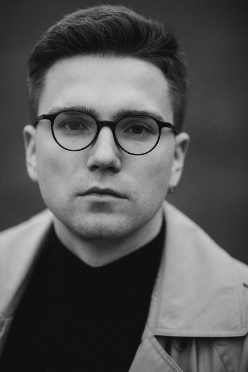 Free Elegant monochrome portrait of a serious man wearing eyeglasses, in a vertical shot. Stock Photo