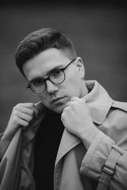 Free Black and white portrait of a man in eyeglasses adjusting his coat. Stock Photo