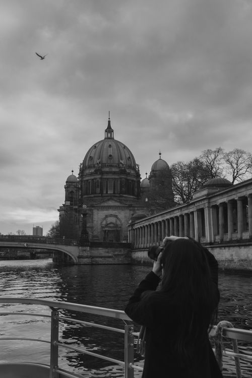 Free Captivating black and white photo of a historic dome by the river in an urban setting. Stock Photo