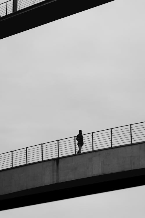 Silhouette of Man on a Bridge in Black and White 