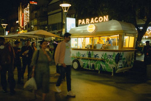 Pedestrians Walking by Street Food Cart in City