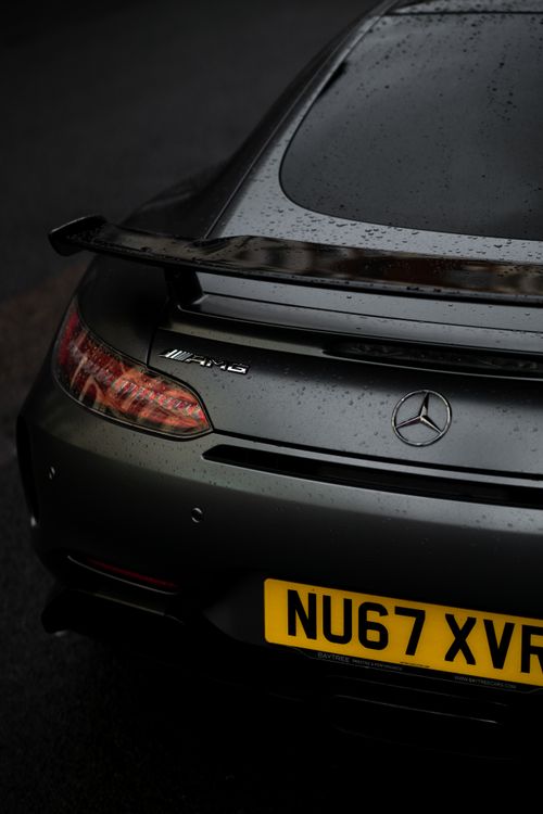 Free Sleek Mercedes AMG car with raindrops, parked in a London street. Modern automotive design captured in moody lighting. Stock Photo