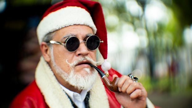 Santa Claus in a red costume, wearing sunglasses and smoking a pipe, creates a cool holiday vibe.