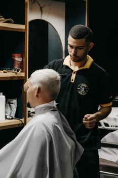 Barber expertly trims a client's hair in a modern barber shop setting.