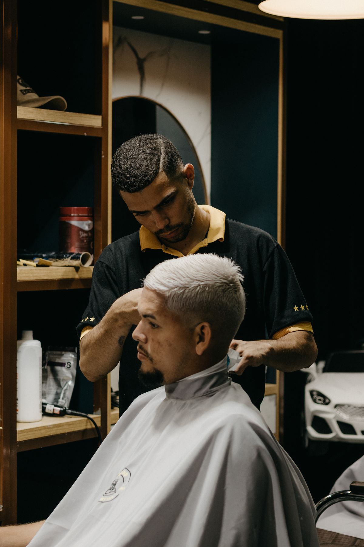 Barbeiro estilizando cabelo de cliente