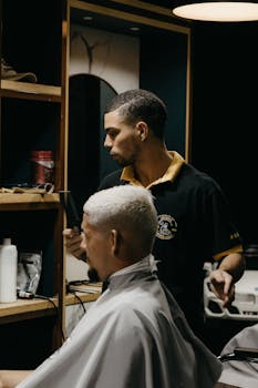 A barber skillfully trims a client's hair in a contemporary barbershop setting.