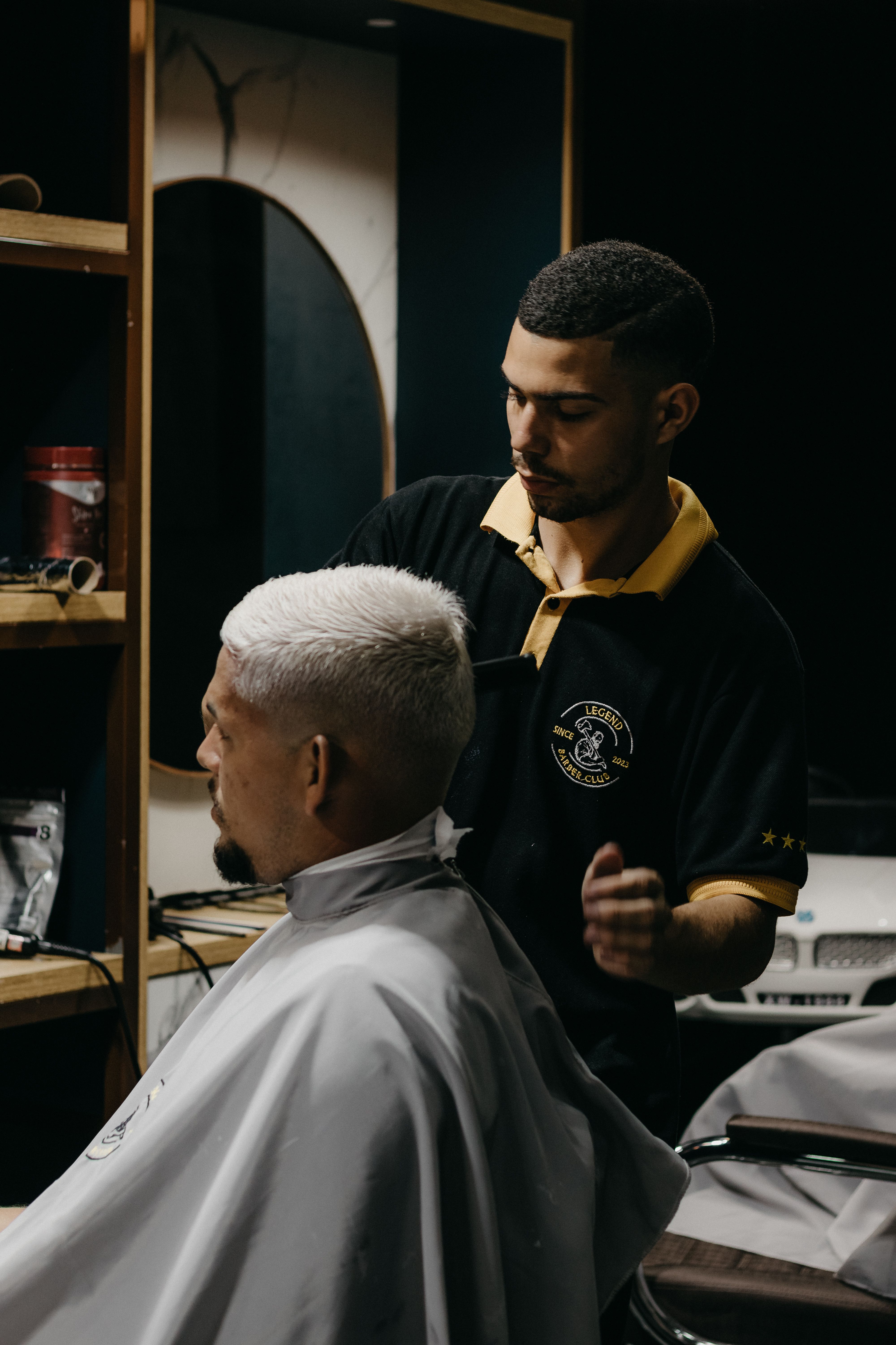 Barber skillfully cuts hair in a modern barbershop setting, focusing on style and precision.