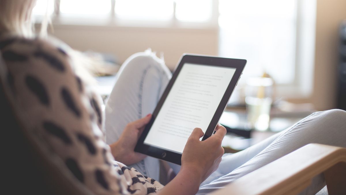 タブレットで読書する女性(イメージ)