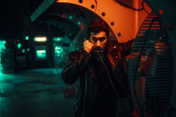 Man on a phone call in a neon-lit street, photo by Wolrider YURTSEVEN on Pexels