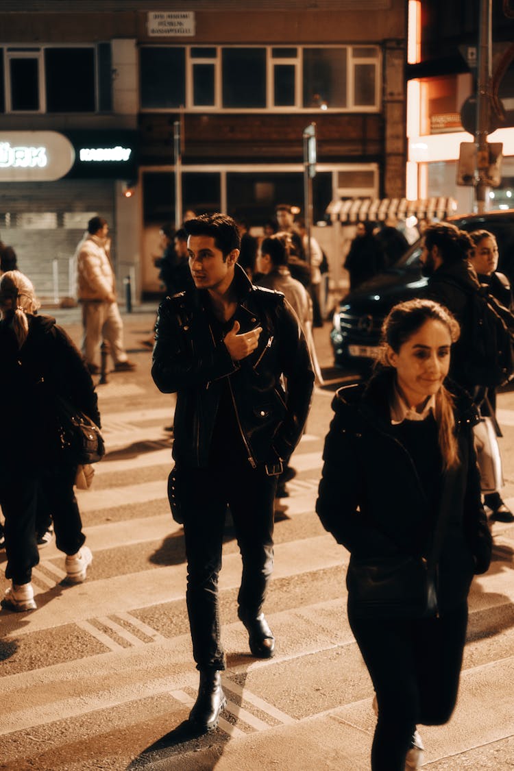 Man In Leather Jacket Walking Among People On Street