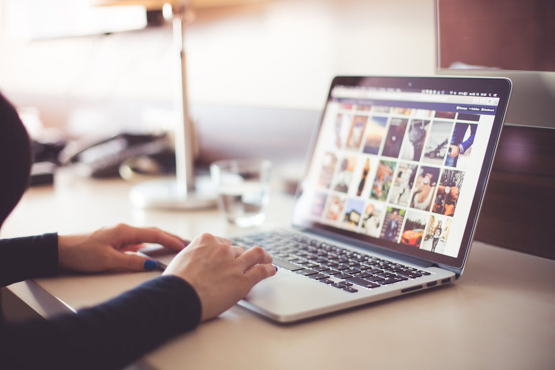 Person Browsing Photos on a Laptop during Daytime