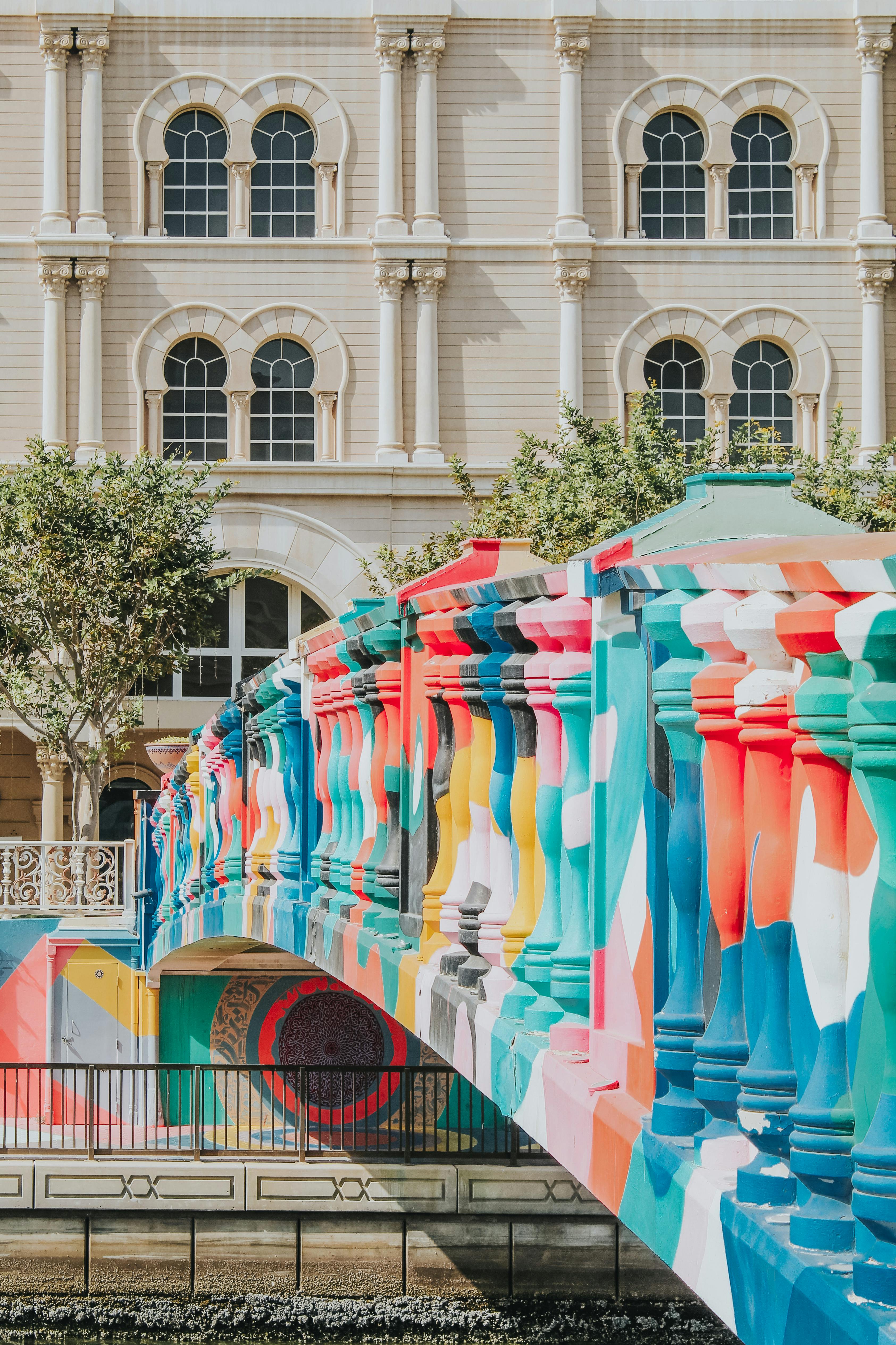 Vibrant mural-covered bridge in Sharjah, UAE with classic architecture in the background.