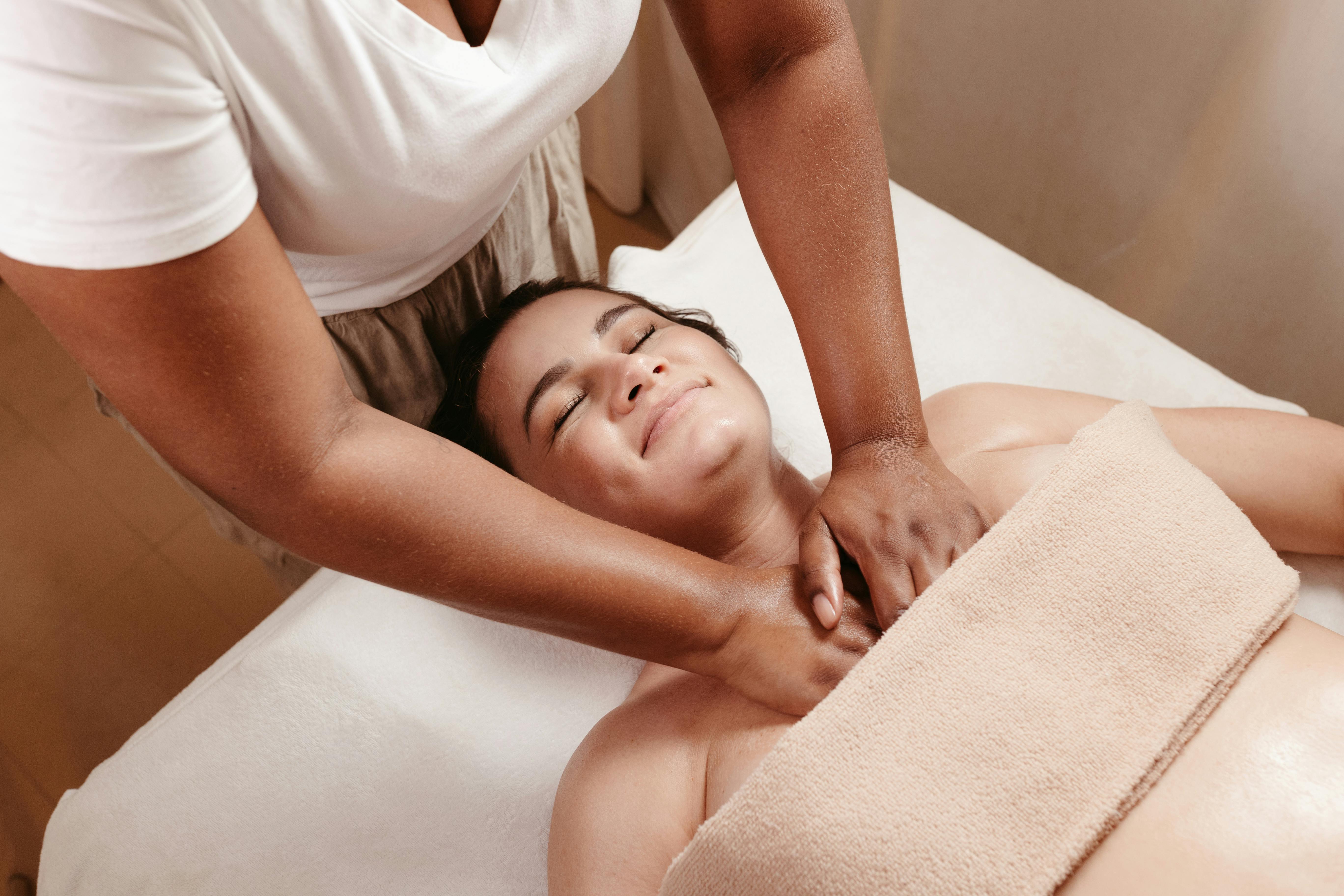 A relaxing spa massage session promoting wellness and peace. Features a smiling woman enjoying therapeutic relief.
