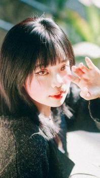 A serene portrait of an Asian woman captured in natural lighting, highlighting her delicate features.