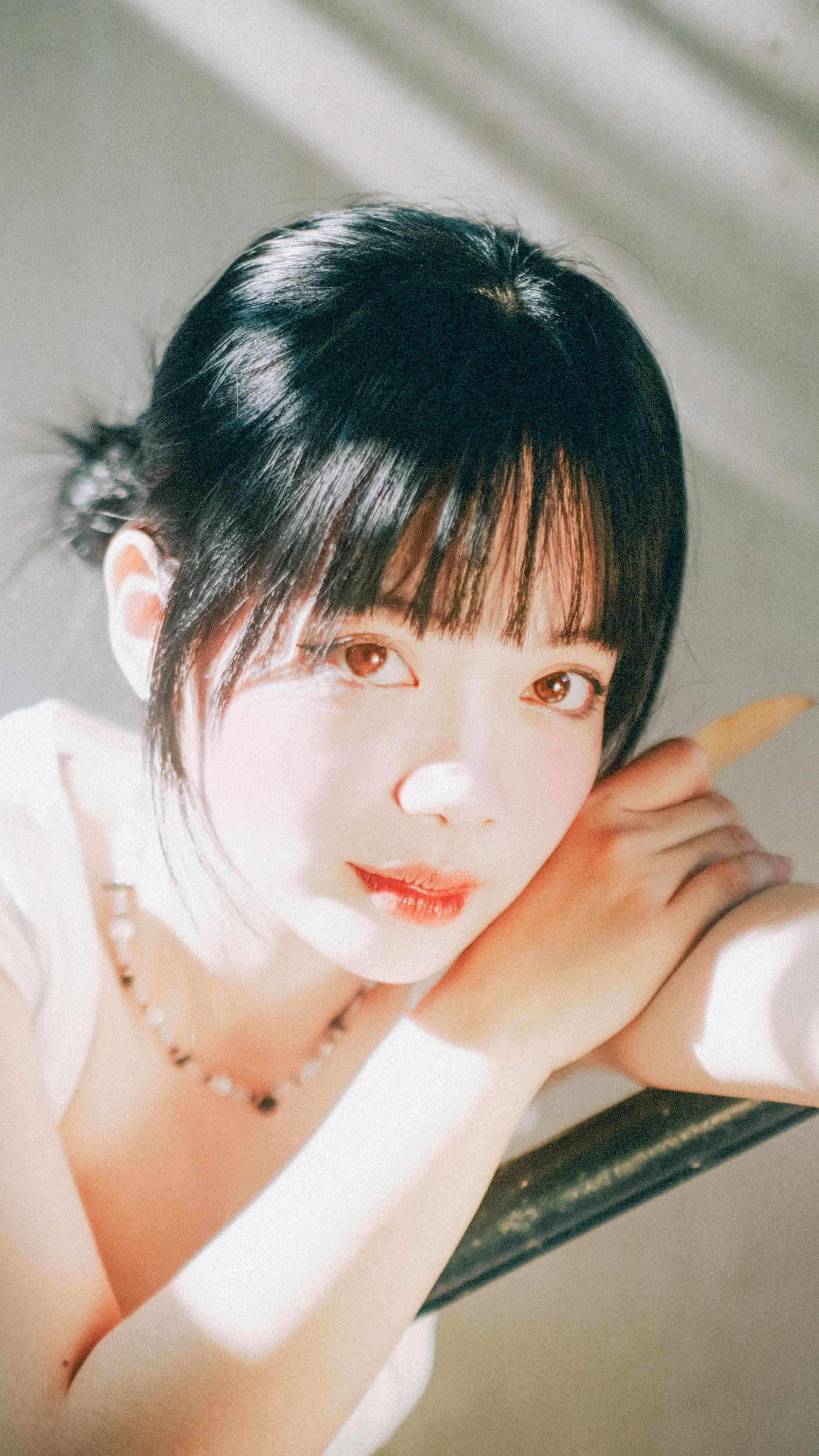 A captivating portrait of a young woman posing elegantly in natural light, conveying beauty and grace.
