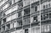 当代建筑立面采用混凝土设计，配有玻璃窗和单色调色板
