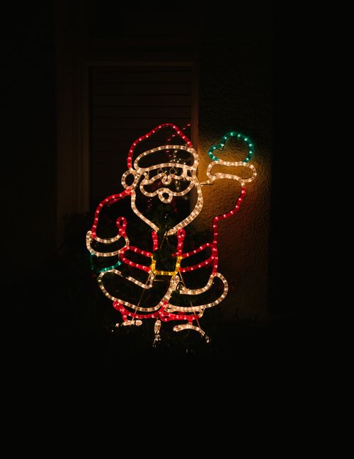 Free Bright Santa Claus light decoration illuminating the night with holiday cheer. Stock Photo