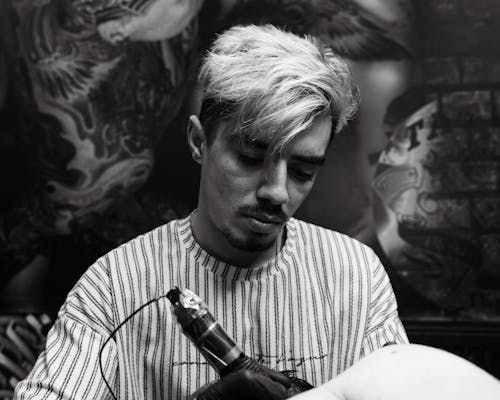 A Tattoo Artist Focused on Doing a Tattoo 