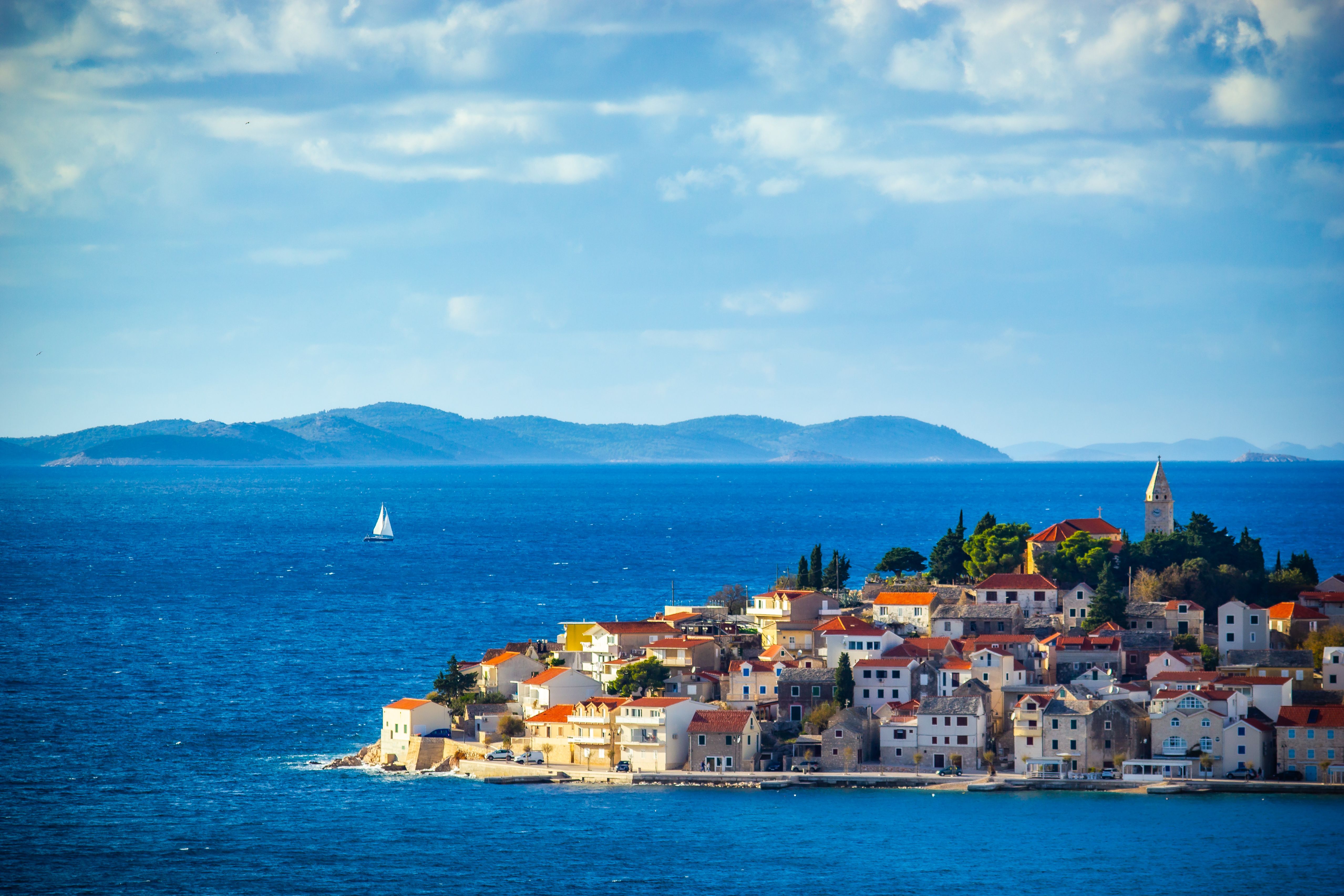 Aerial view of Primošten, Croatia, with its charming coastline and vibrant blue sea in summer. Aerial view of Primošten, Croatia, with its charming coastline and vibrant blue sea in summer.