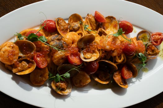 A savory seafood pasta dish featuring clams, cherry tomatoes, and roe in a light sauce.