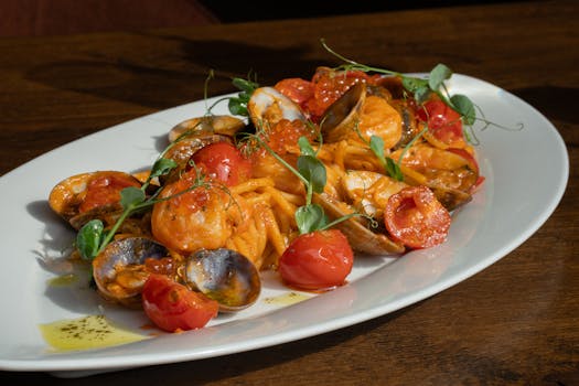 A tempting seafood pasta dish garnished with fresh cherry tomatoes and herbs.