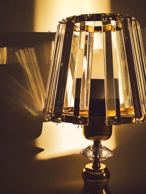 Free Close-up of a decorative crystal lamp with warm light and dramatic shadow play. Stock Photo