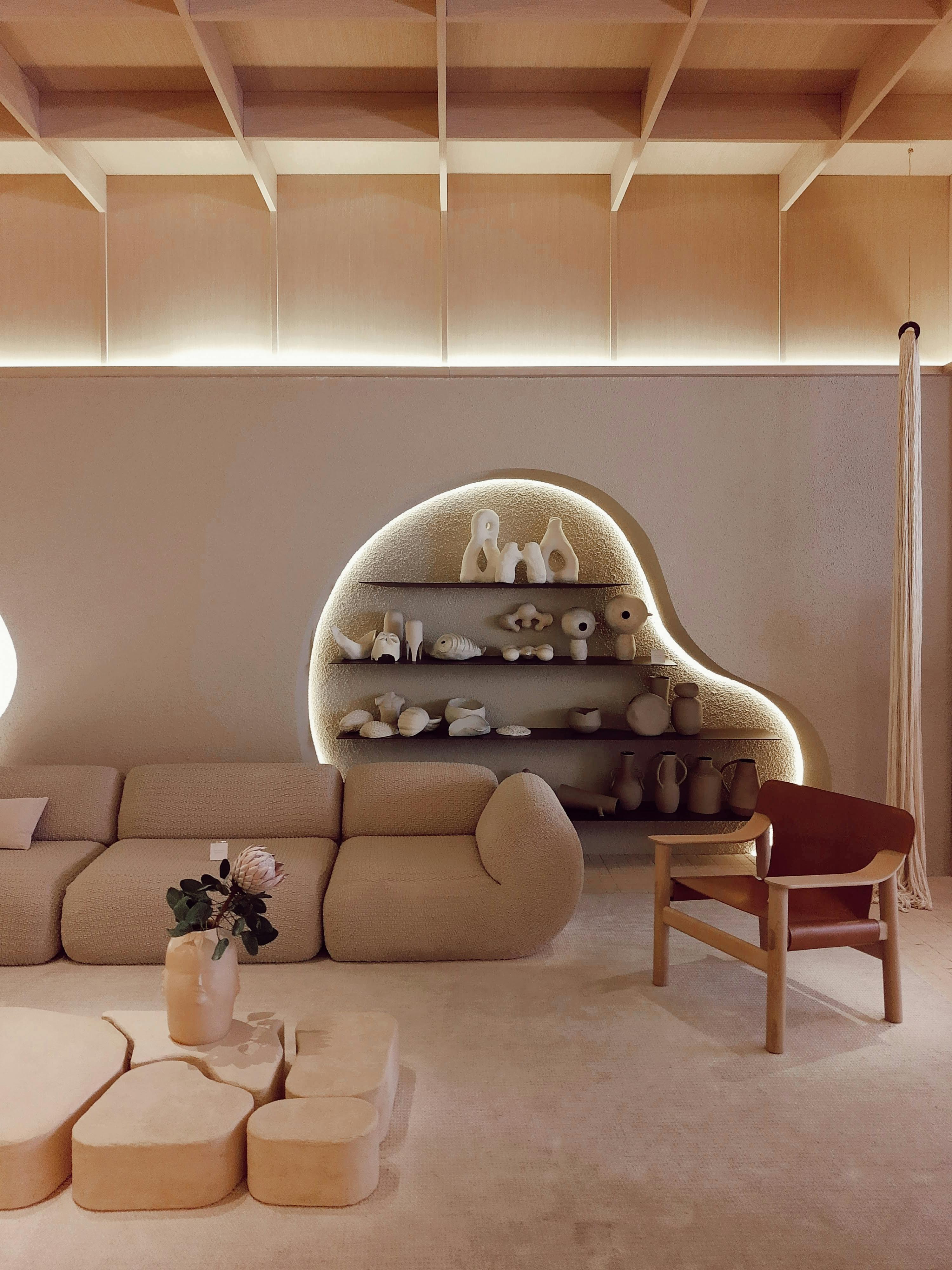 A beige modern living room with minimal decor and creative lighting, located in SP, Brazil.