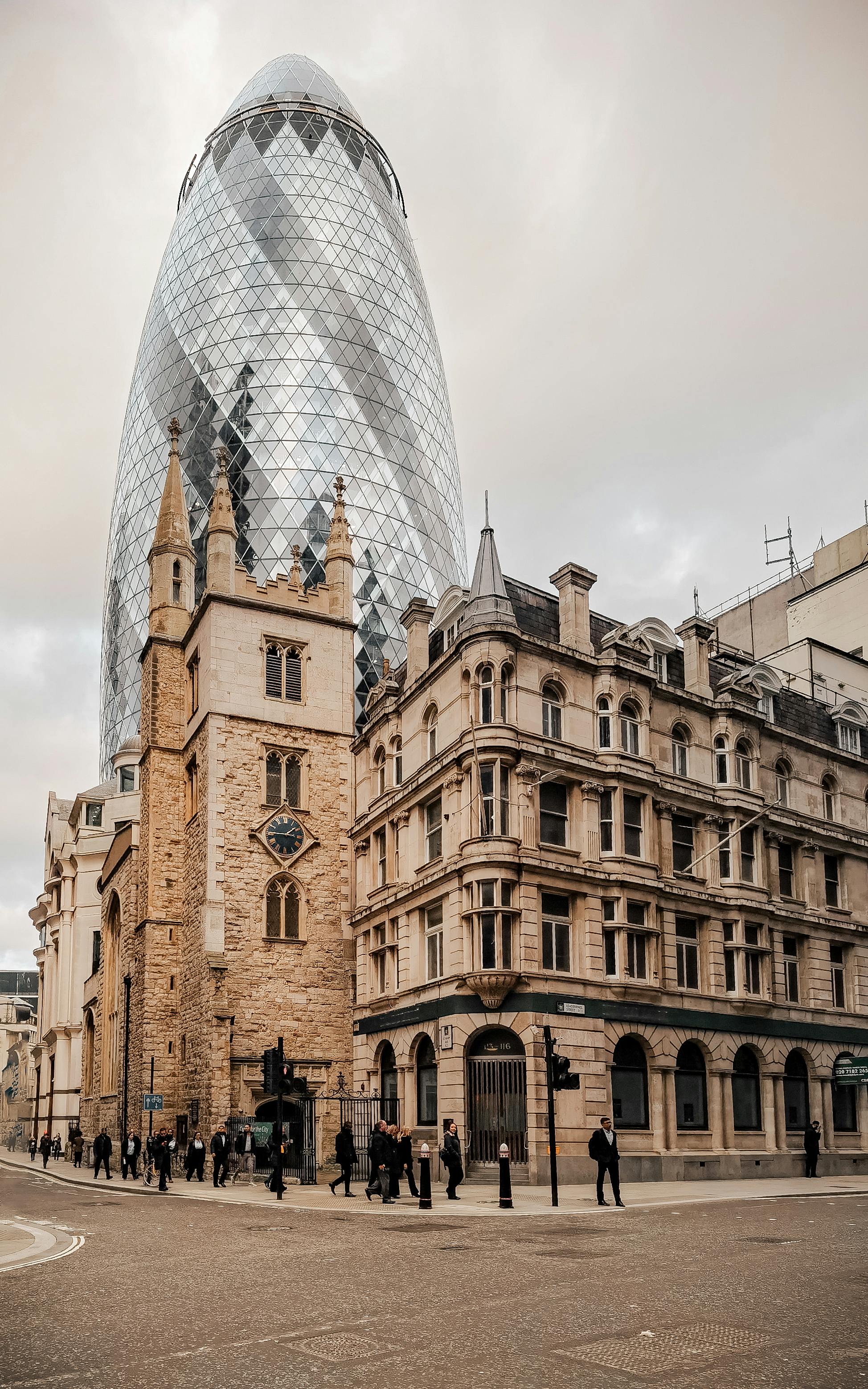 View of 30 St Mary Axe skyscraper and historic architecture in London.