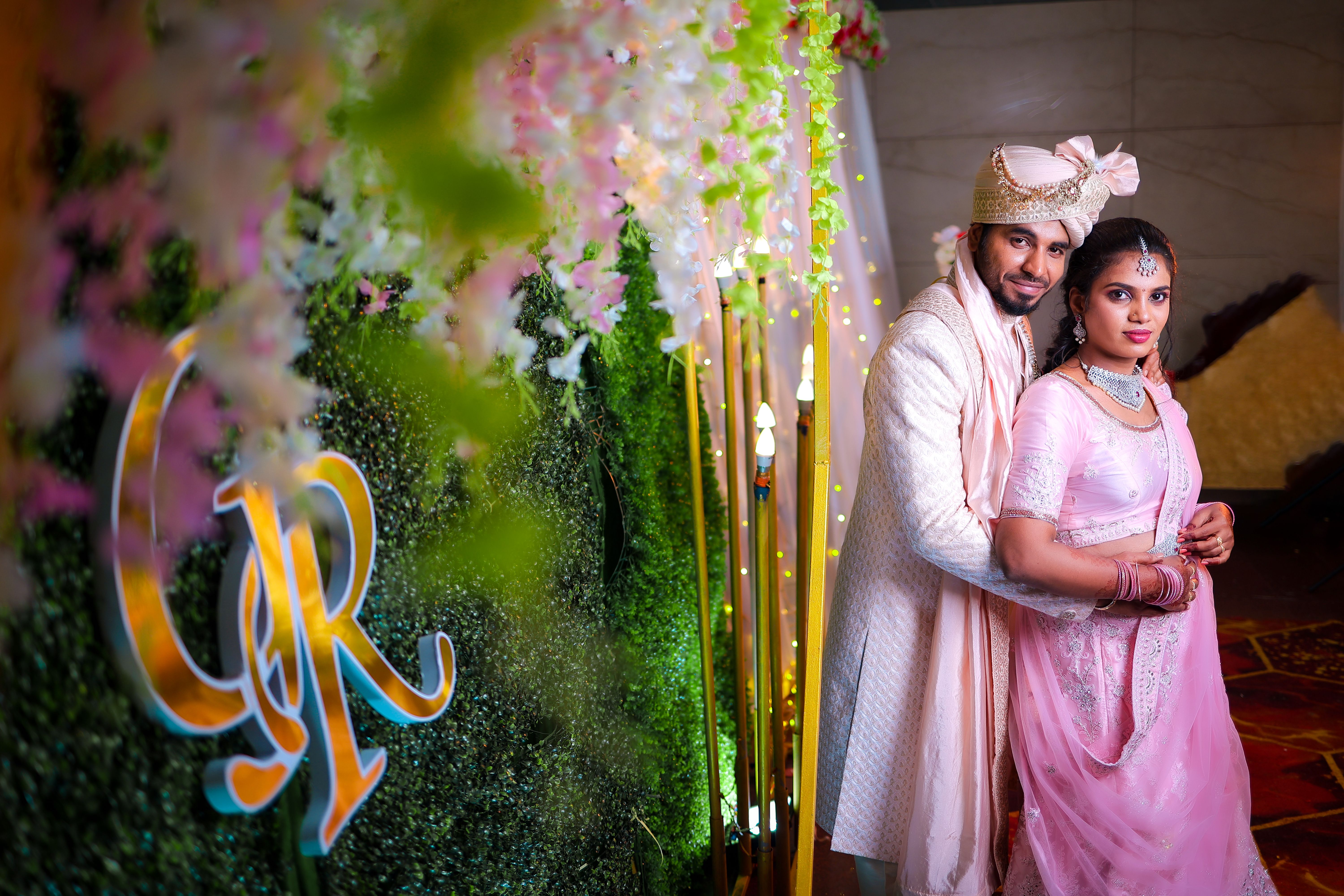 Elegant Indian couple in traditional attire captured during their wedding ceremony indoors.
