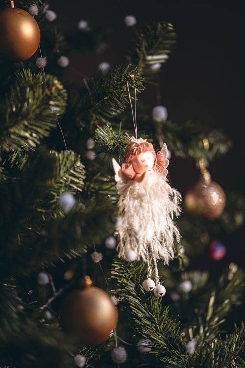 Free A close-up of a Christmas tree decorated with an angel ornament, captured in Lisboa, Portugal. Stock Photo