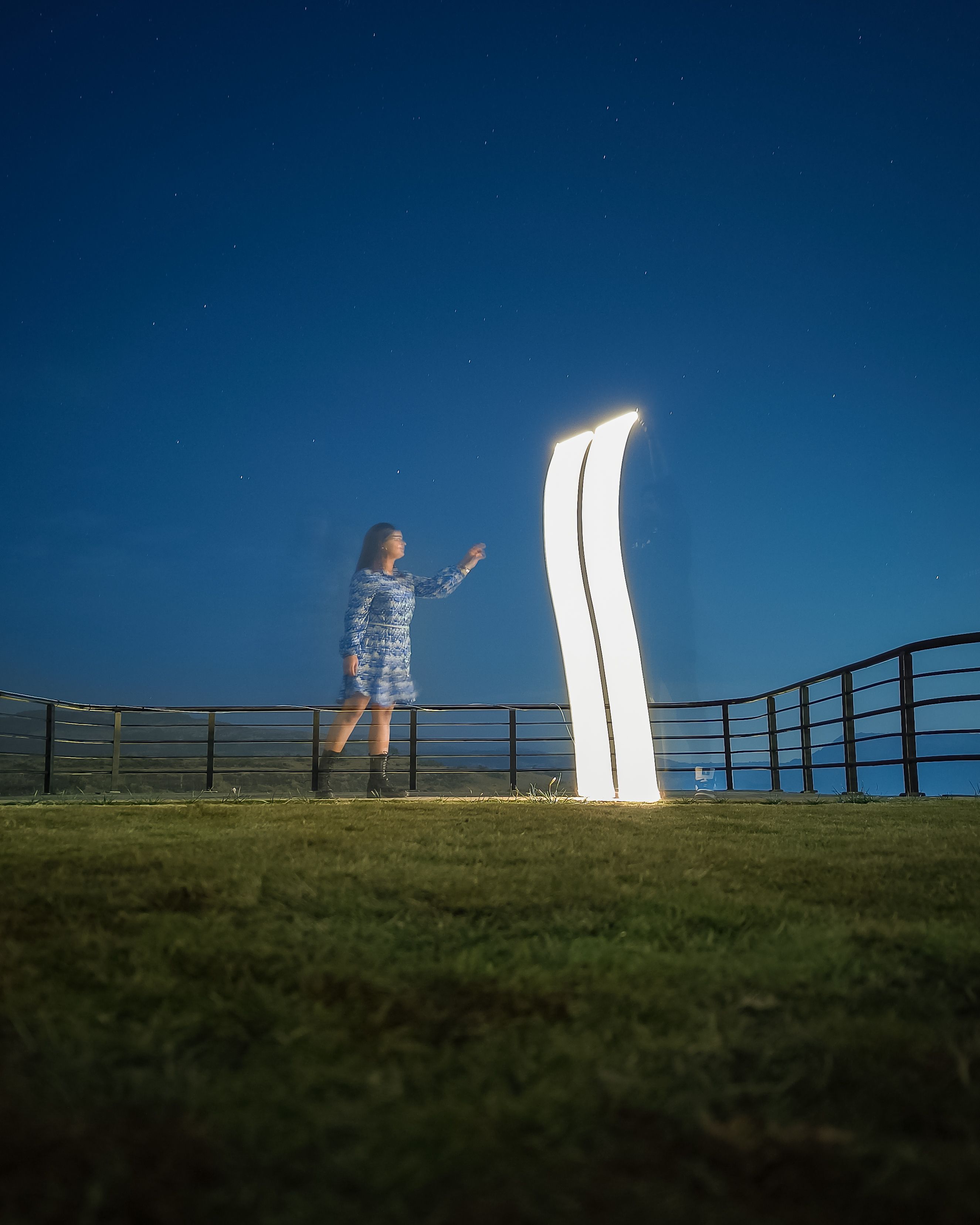 Woman Standing by Light on Grass at Night · Free Stock Photo